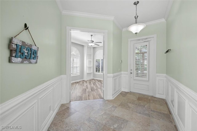 entryway with ceiling fan and crown molding