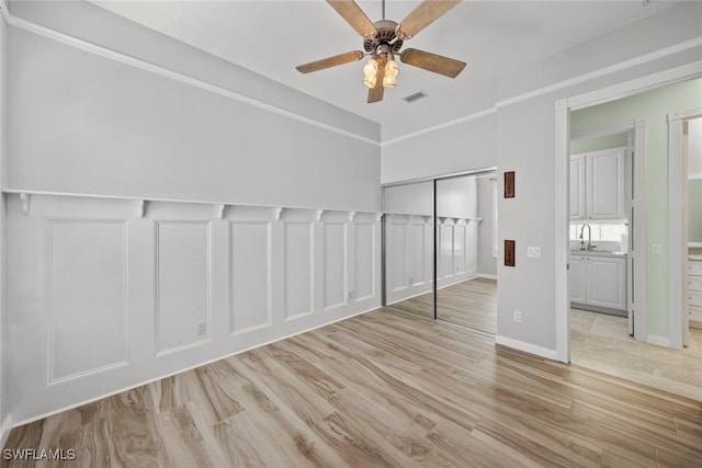 unfurnished bedroom with ceiling fan, sink, and light hardwood / wood-style floors