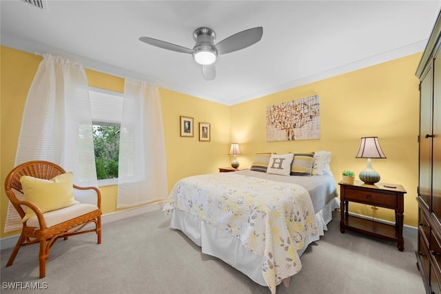 bedroom with light carpet, ornamental molding, a ceiling fan, and baseboards