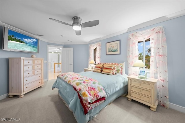 bedroom featuring baseboards, visible vents, a ceiling fan, light colored carpet, and ornamental molding