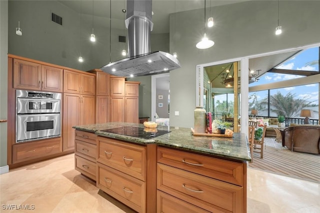 kitchen featuring pendant lighting, a towering ceiling, island exhaust hood, double oven, and black electric cooktop