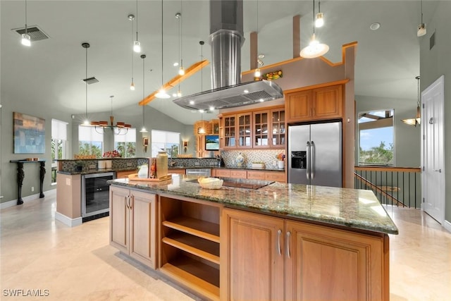 kitchen with island range hood, stainless steel appliances, beverage cooler, dark stone counters, and hanging light fixtures