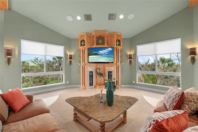 living area with light carpet, lofted ceiling, visible vents, and a glass covered fireplace