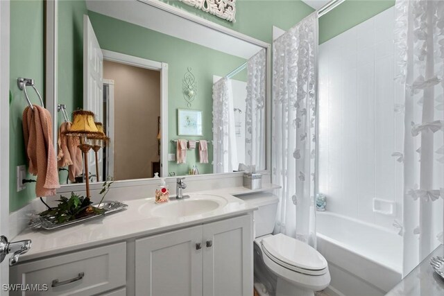 full bathroom featuring toilet, shower / bath combination with curtain, and vanity