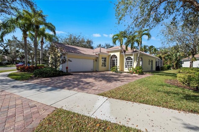 mediterranean / spanish-style house featuring a front yard and a garage