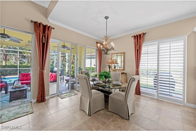 dining space featuring ceiling fan with notable chandelier, light tile patterned flooring, and ornamental molding