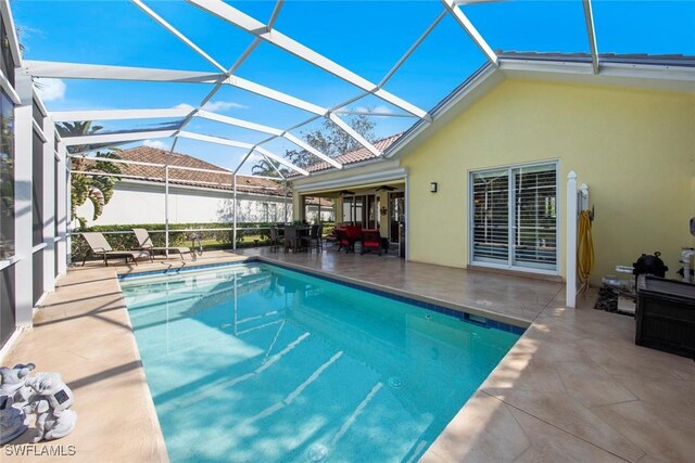 view of pool featuring a lanai, a patio area, and ceiling fan