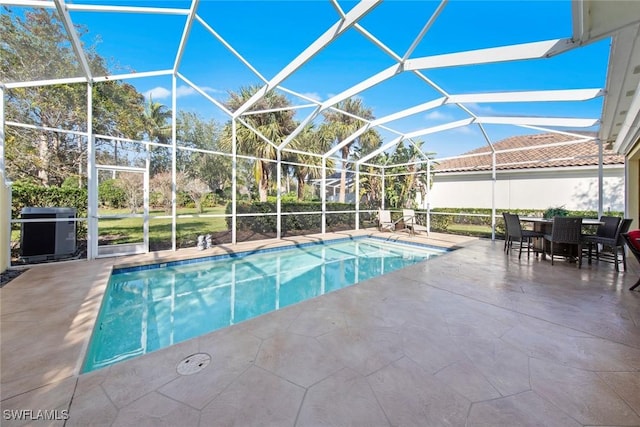 view of swimming pool with area for grilling, glass enclosure, and a patio