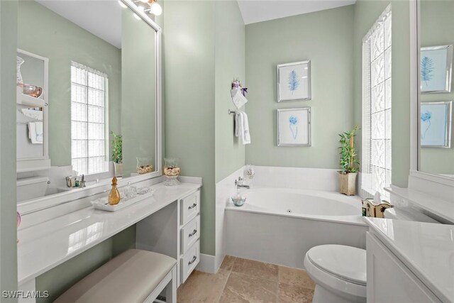 bathroom with toilet, a tub, and vanity