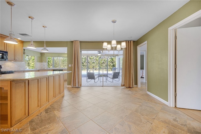 kitchen featuring pendant lighting, light stone countertops, decorative backsplash, and stove