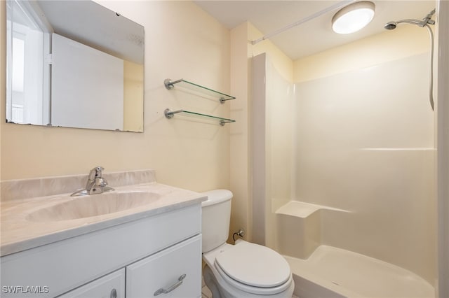 bathroom featuring vanity, walk in shower, and toilet