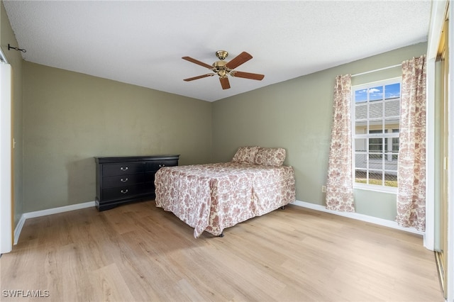 bedroom with multiple windows, hardwood / wood-style flooring, and ceiling fan