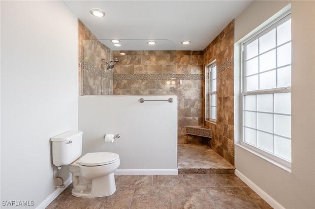 bathroom with tiled shower and toilet