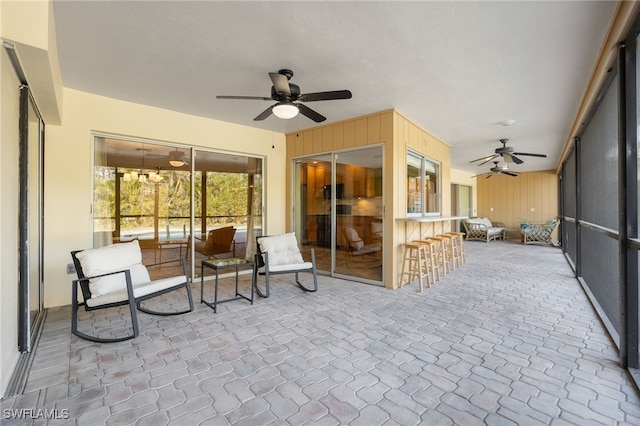 sunroom featuring ceiling fan