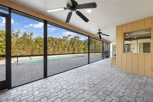 unfurnished sunroom with ceiling fan