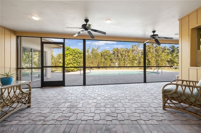 sunroom / solarium featuring ceiling fan