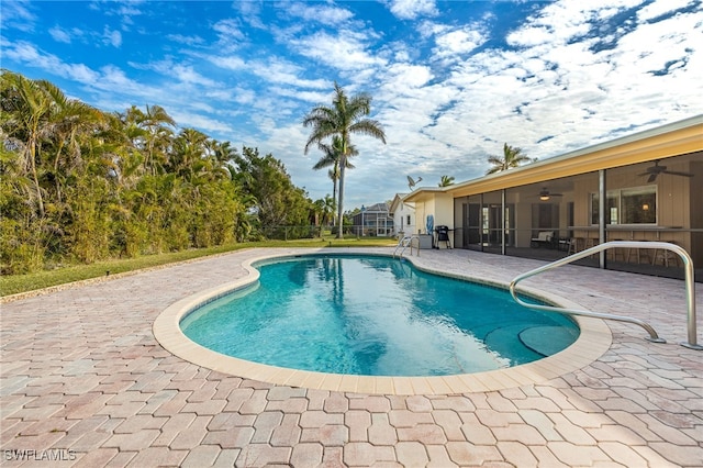 view of pool featuring a patio area, a sunroom, and ceiling fan