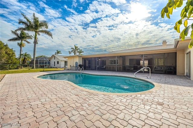 view of pool with a patio and a sunroom