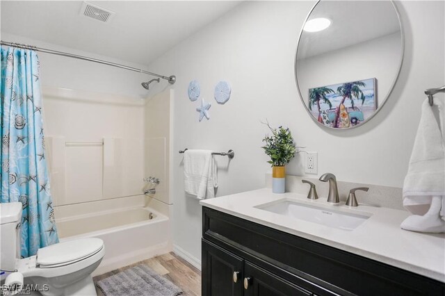 full bathroom featuring hardwood / wood-style flooring, vanity, toilet, and shower / tub combo