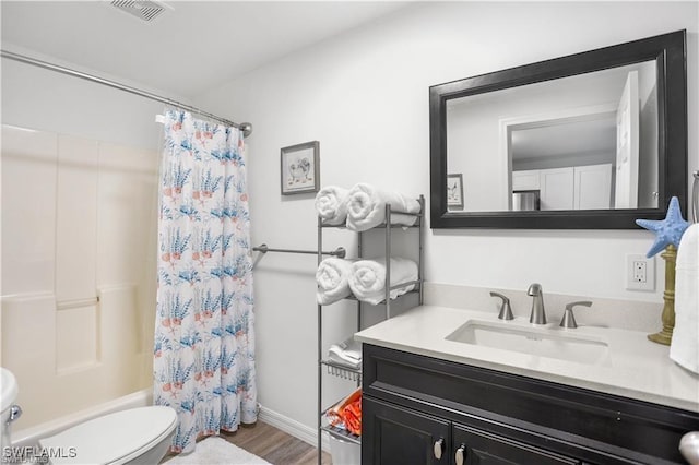 full bathroom featuring hardwood / wood-style flooring, vanity, shower / tub combo with curtain, and toilet