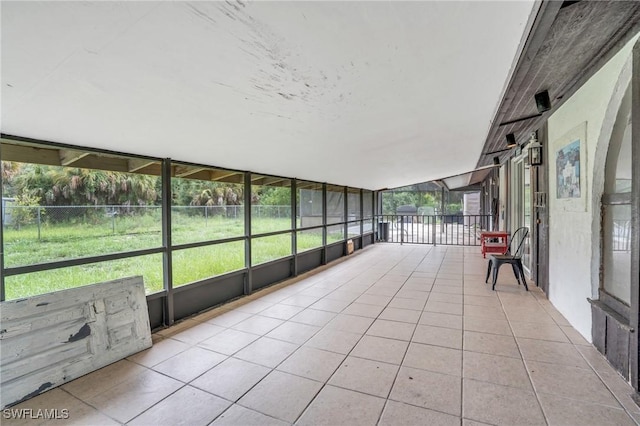 unfurnished sunroom featuring vaulted ceiling