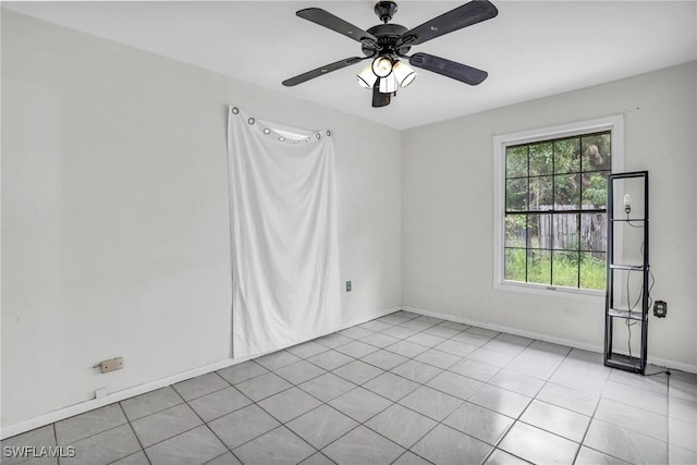 unfurnished room featuring a wealth of natural light, ceiling fan, and light tile patterned flooring