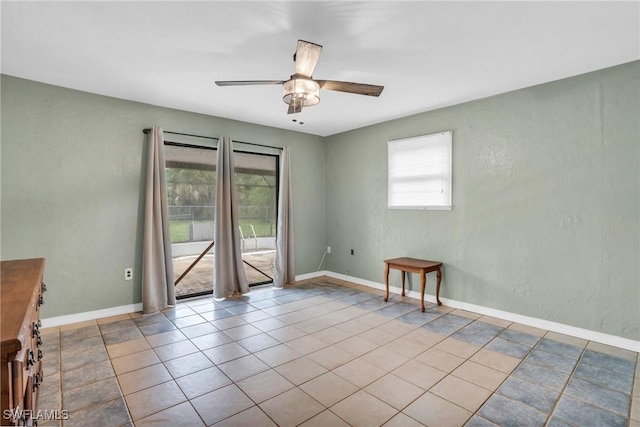 tiled spare room featuring ceiling fan