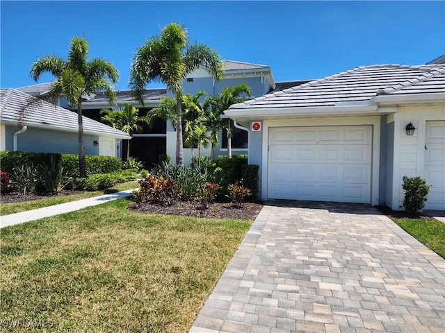 ranch-style home with a garage and a front lawn