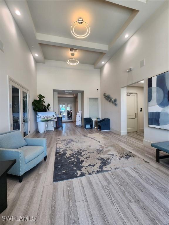 hall featuring a high ceiling and light hardwood / wood-style flooring