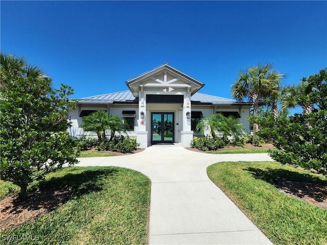 view of front facade with a front yard and french doors