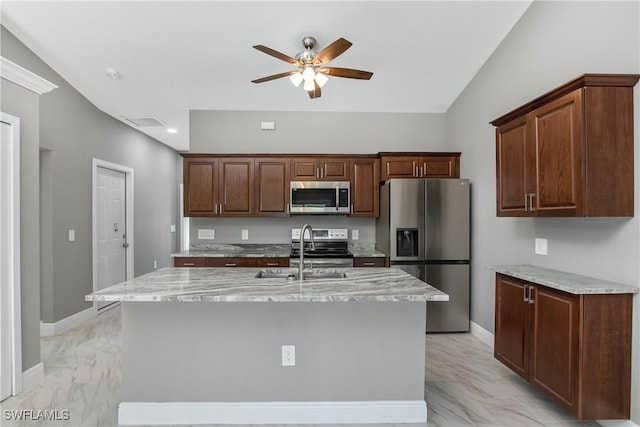 kitchen with appliances with stainless steel finishes, ceiling fan, sink, and a center island with sink