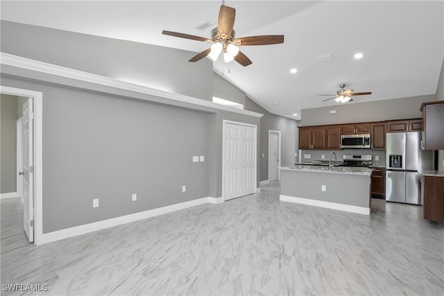 kitchen featuring stainless steel appliances, sink, ceiling fan, high vaulted ceiling, and a center island with sink