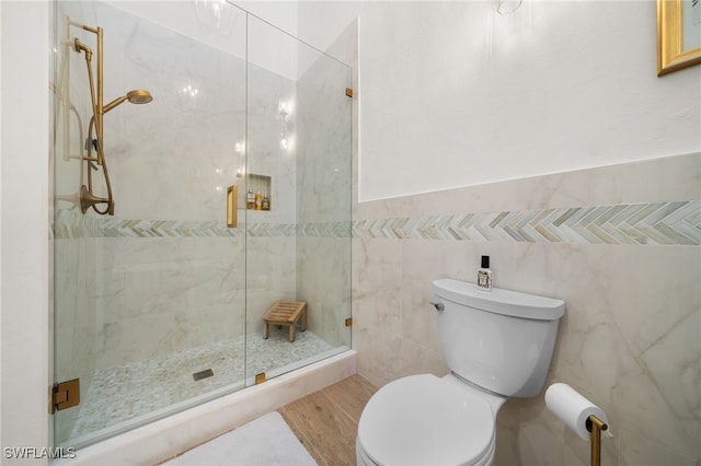 bathroom with toilet, an enclosed shower, and tile walls