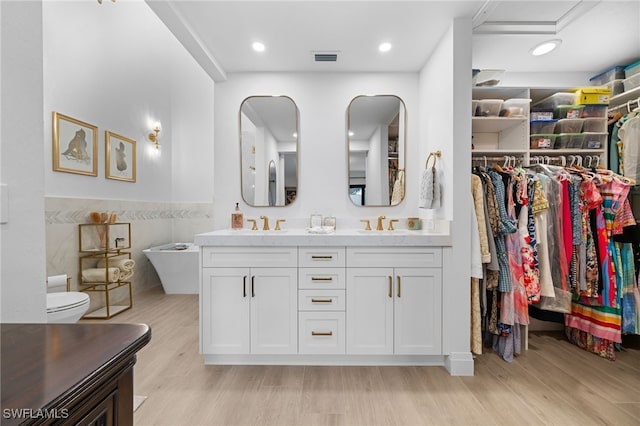 bathroom with vanity, hardwood / wood-style floors, and tile walls