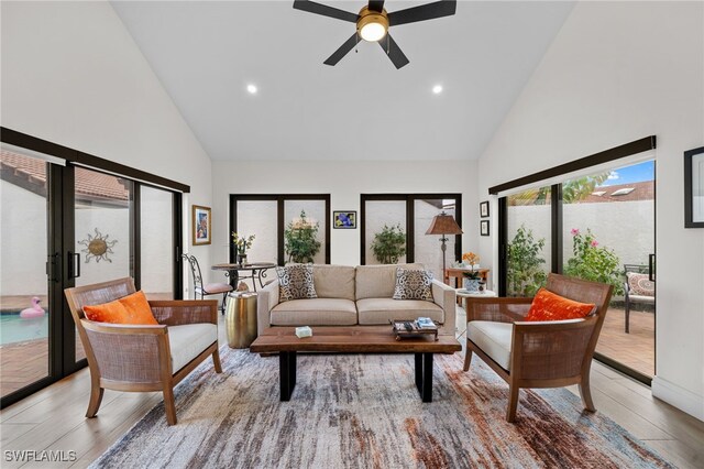 living room featuring high vaulted ceiling, light hardwood / wood-style floors, french doors, and ceiling fan