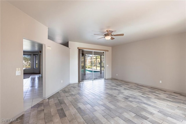 unfurnished room featuring a ceiling fan, light wood-style floors, and baseboards