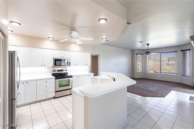 kitchen with appliances with stainless steel finishes, white cabinets, and ceiling fan