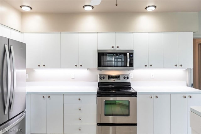 kitchen featuring stainless steel appliances, white cabinetry, and light countertops