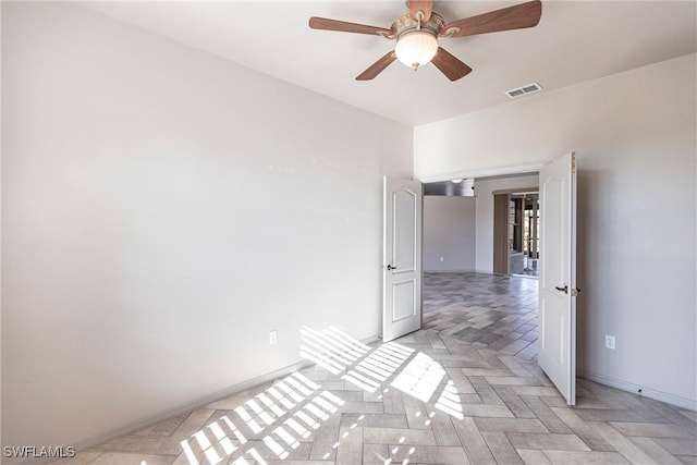 unfurnished room with visible vents, baseboards, and a ceiling fan