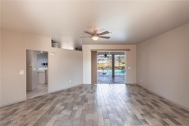 unfurnished room with visible vents, wood finished floors, baseboards, and ceiling fan