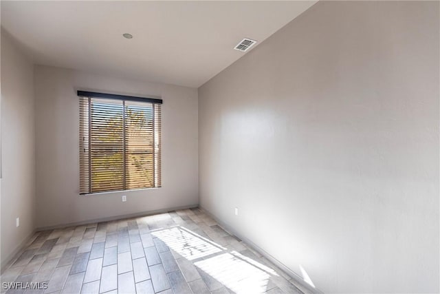 spare room with light wood-style floors and visible vents