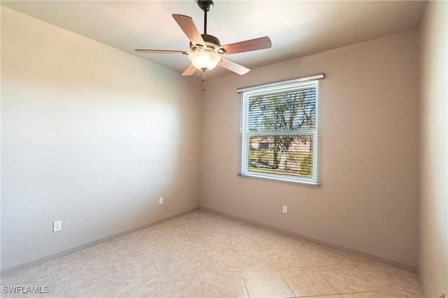 empty room featuring light tile patterned floors, baseboards, and a ceiling fan