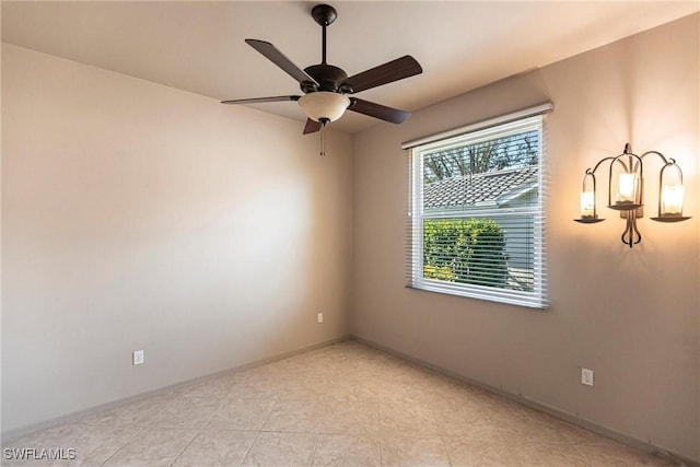 unfurnished room featuring a ceiling fan and baseboards