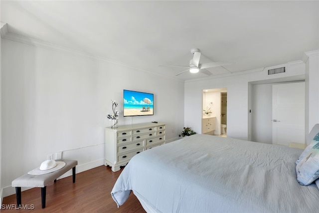 bedroom with crown molding, dark hardwood / wood-style floors, ensuite bathroom, and ceiling fan