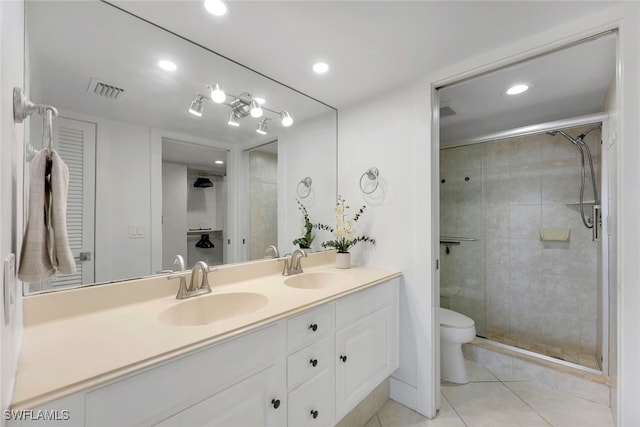 bathroom featuring vanity, a shower with shower door, tile patterned floors, and toilet