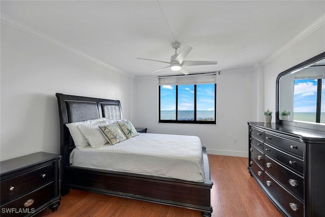 bedroom featuring multiple windows, crown molding, and light hardwood / wood-style flooring