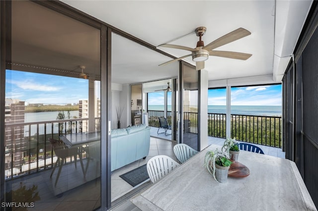 sunroom with a water view and ceiling fan