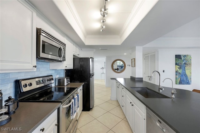 kitchen featuring a raised ceiling, white cabinetry, sink, stainless steel appliances, and crown molding