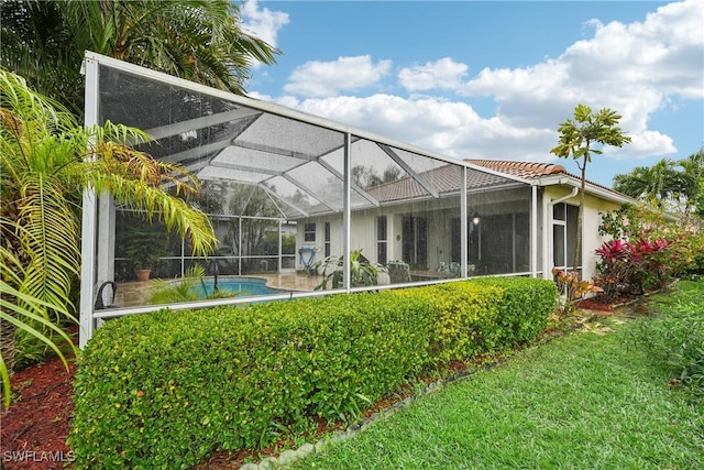 back of house featuring a patio area and glass enclosure