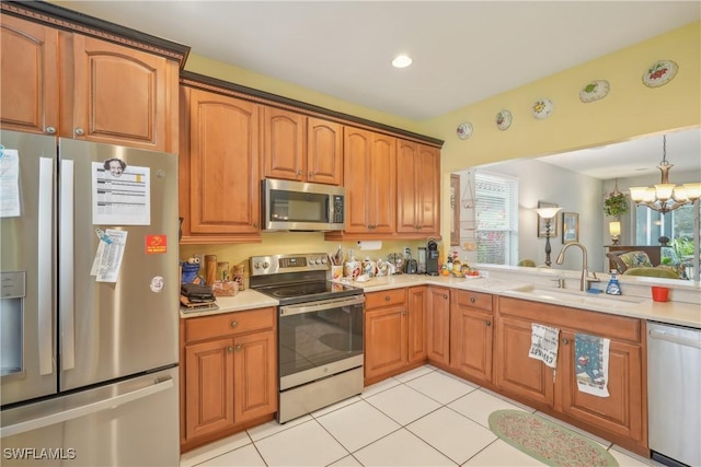 kitchen with an inviting chandelier, sink, light tile patterned floors, and stainless steel appliances